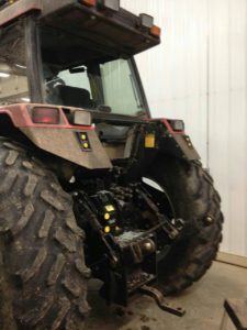 A large truck with big tires is parked in a garage.