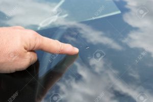 A person touching the glass of a car